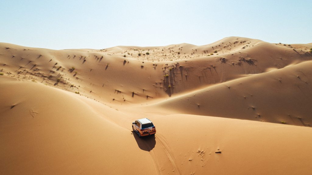 Allradfahrzeug fährt offroad durch die Wüste in Abu Dhabi